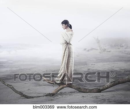 Stock Photo - Hispanic woman in blanket at beach. Fotosearch