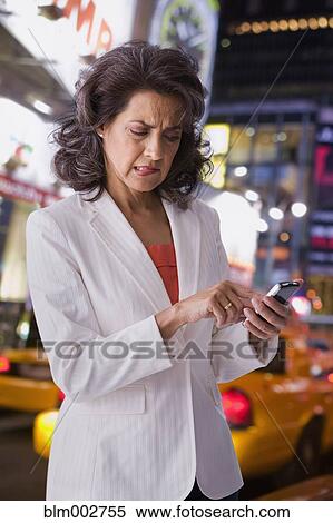 Hispanic woman in city using cell phone and making a face View Large Photo Image Stock Photography - Hispanic woman in city using cell phone and making a face. Fotosearch