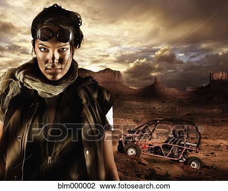 Stock Image - Hispanic woman in front of dune buggy. Fotosearch