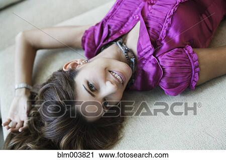 Stock Image - Hispanic woman laying on sofa. Fotosearch