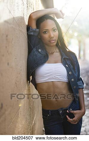 Stock Photo - Hispanic woman leaning against wall. Fotosearch