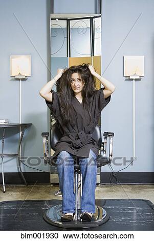 Hispanic woman pulling on hair in salon View Large Photo Image Stock Image - Hispanic woman pulling on hair in salon. Fotosearch