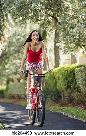 Hispanic woman riding bicycle outdoors View Large Photo Image Stock Photo - Hispanic woman riding bicycle outdoors. Fotosearch