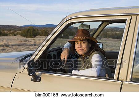 Stock Photo - Hispanic woman sitting in truck. Fotosearch