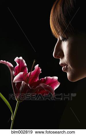 Stock Photo - Hispanic woman smelling flower. Fotosearch