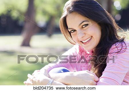 Stock Photography - Hispanic woman smiling outdoors. Fotosearch