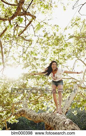 Hispanic woman standing on tree branch View Large Photo Image Stock Photo - Hispanic woman standing on tree branch. Fotosearch