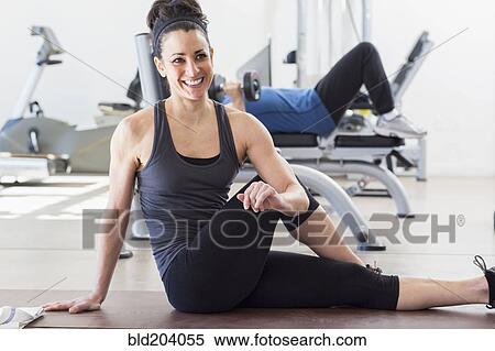 Stock Photography - Hispanic woman stretching in gym. Fotosearch