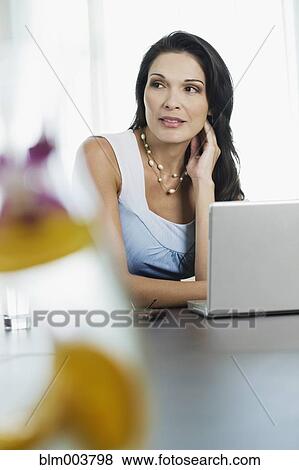 Stock Photo - Hispanic woman using laptop. Fotosearch