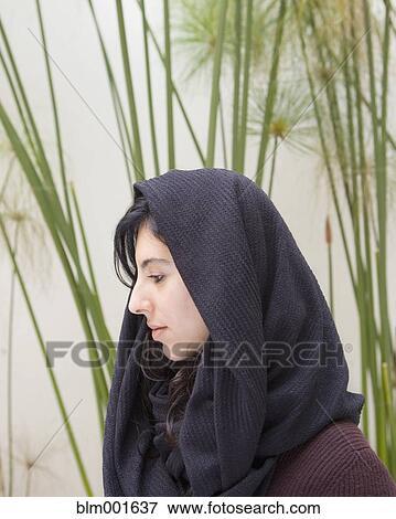 Stock Photo - Hispanic woman wearing scarf over head. Fotosearch