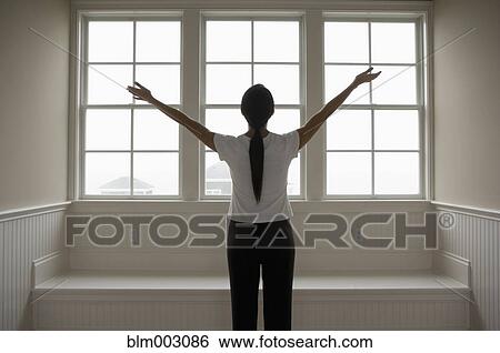Stock Photograph - Hispanic woman with arms outstretched. Fotosearch