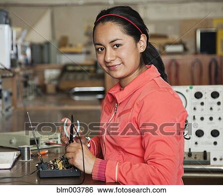 Stock Photograph - Hispanic woman working in electronics lab. Fotosearch