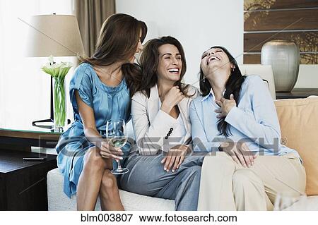 Hispanic women laughing on sofa View Large Photo Image Stock Photo - Hispanic women laughing on sofa. Fotosearch