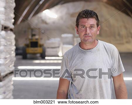 Stock Image - Hispanic worker in factory warehouse. Fotosearch