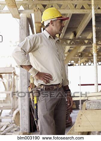 Stock Image - Hispanic worker standing at construction site. Fotosearch