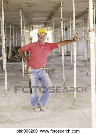 Hispanic worker standing on construction site View Large Photo Image Stock Image - Hispanic worker standing on construction site. Fotosearch
