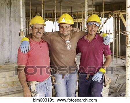 Stock Photography - Hispanic workers hugging on construction site. Fotosearch