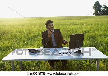 Stock Photo - Indian businessman at Help Desk in field. Fotosearch