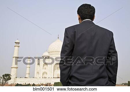 Stock Image - Indian businessman visiting the Taj Mahal. Fotosearch