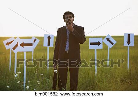 Indian businessman with arrow signs in field View Large Photo Image Stock Image - Indian businessman with arrow signs in field. Fotosearch