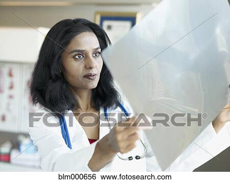 Indian doctor reviewing x-rays View Large Photo Image Stock Photograph - Indian doctor reviewing x-rays. Fotosearch