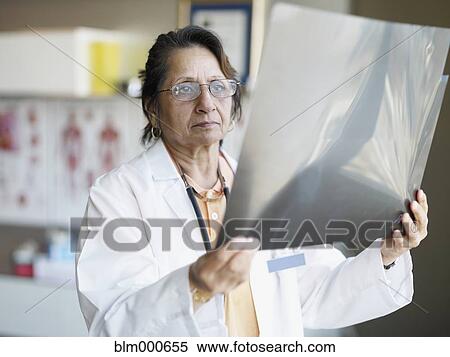 Stock Photography - Indian doctor reviewing x-rays. Fotosearch