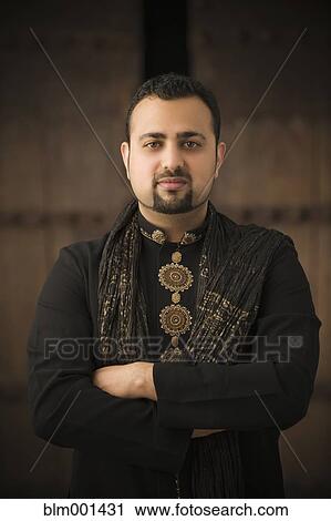 Stock Image - Indian man with arms crossed in traditional clothing. Fotosearch
