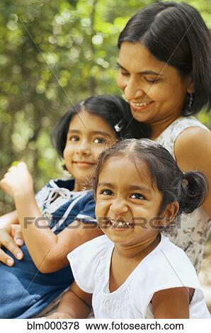 Indian mother sitting with daughters outdoors View Large Photo Image Stock Photo - Indian mother sitting with daughters outdoors. Fotosearch