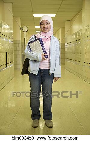 Indonesian teenager wearing headscarf in school hallway View Large Photo Image Stock Photo - Indonesian teenager wearing headscarf in school hallway. Fotosearch