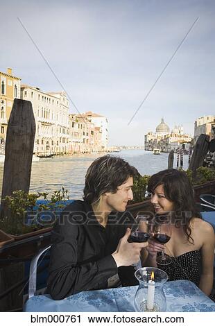 Stock Image - Italian couple drinking red wine at sidewalk cafe. Fotosearch