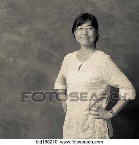 Stock Image - Japanese woman smiling with hands on hips. Fotosearch