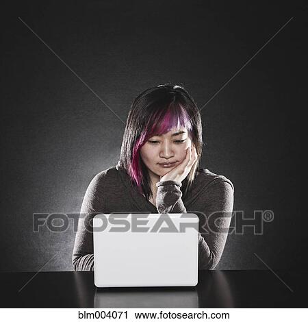 Stock Image - Japanese woman using laptop. Fotosearch