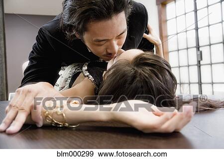 Stock Photo - Korean couple being intimate on table. Fotosearch