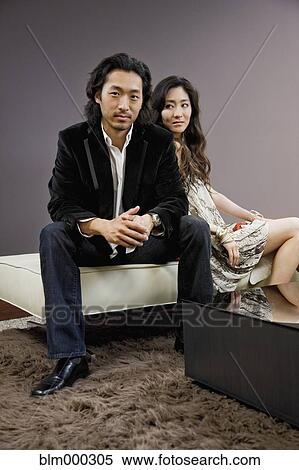Stock Photography - Korean couple sitting on stool. Fotosearch