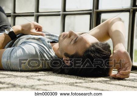 Stock Photo - Korean man laying on floor. Fotosearch