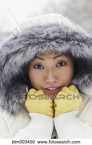 Stock Image - Korean woman in fur-hooded coat. Fotosearch