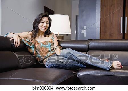 Korean woman relaxing on sofa View Large Photo Image Picture - Korean woman relaxing on sofa. Fotosearch