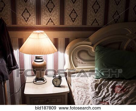 Stock Photo - Lamp on bedside table in bedroom. Fotosearch