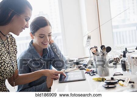 Makeup artist using digital tablet with client View Large Photo Image Stock Photo - Makeup artist using digital tablet with client. Fotosearch