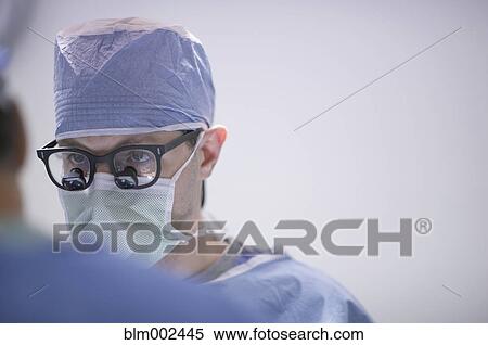 Stock Photography - Male doctor wearing magnifying glasses. Fotosearch