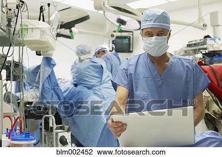 Male doctor with laptop in operating room View Large Photo Image Stock Image - Male doctor with laptop in operating room. Fotosearch