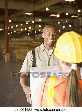 Male warehouse worker handing box to female warehouse worker View Large Photo Image Stock Image - Male warehouse worker handing box to female warehouse worker. Fotosearch