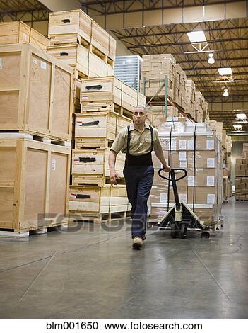 Male warehouse working pulling pallet of boxes View Large Photo Image Stock Image - Male warehouse working pulling pallet of boxes. Fotosearch