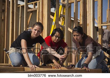 Stock Photograph - Man and women working at construction site. Fotosearch