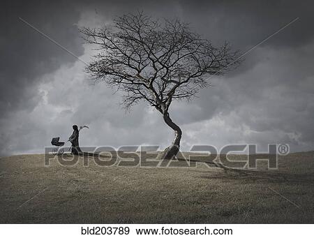 Stock Photo - Man in black robes with baby carriage by dead tree. Fotosearch
