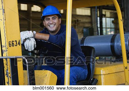 Man in hard hat driving warehouse equipment View Large Photo Image Stock Image - Man in hard hat driving warehouse equipment. Fotosearch