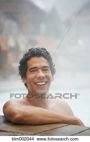 Picture - Man sitting in hot tub. Fotosearch