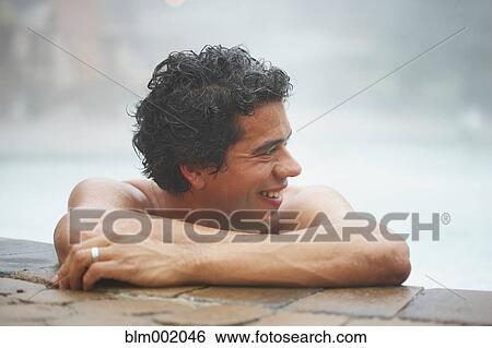 Stock Photograph - Man sitting in hot tub. Fotosearch