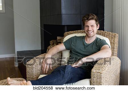 Man smiling in armchair View Large Photo Image Stock Photo - Man smiling in armchair. Fotosearch