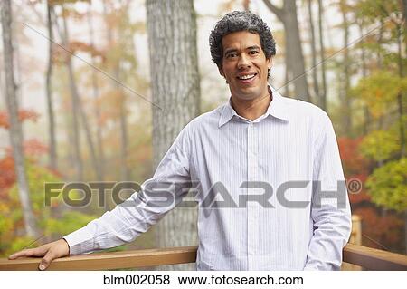Stock Photo - Man standing on deck in woods. Fotosearch